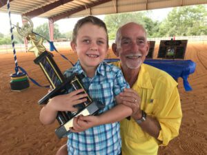 A man and boy holding up a toy airplane.