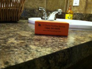 A bathroom counter with a business card on it.