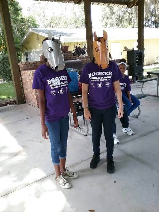 Two people wearing purple shirts and masks