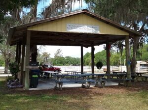 A picnic shelter with benches and tables in the middle of it.