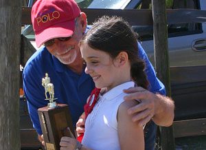 A man and girl holding a trophy